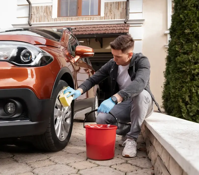 Lavage auto à domicile Sarrouilles : professionnel intervenant sur un véhicule